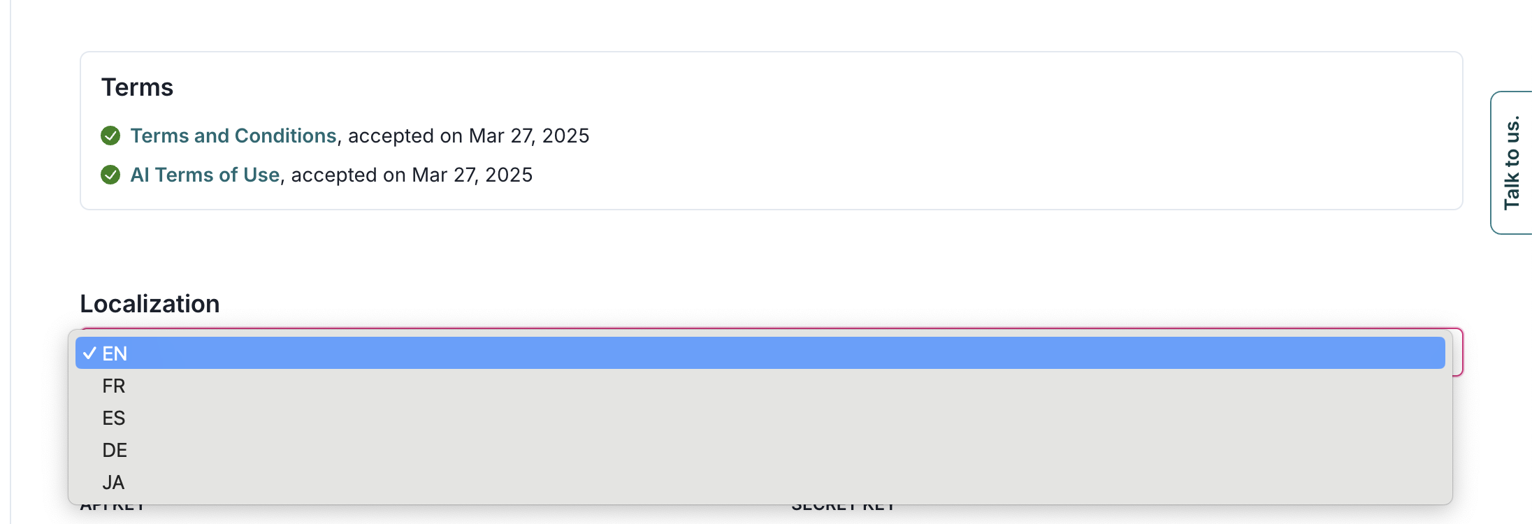 The image shows a user interface section with a title labeled Terms, displaying two items: Terms and Conditions and Terms of Use, both marked with green check icons and accepted on March 27, 2025. Below this section, there is a title labeled Localization with a dropdown menu. The dropdown menu is expanded, showing language options including EN, FR, ES, DE, and JA, with EN highlighted in blue, indicating it is selected. On the right side, there is a vertical Talk to us button. The layout is minimalistic with a white background and a clean design.