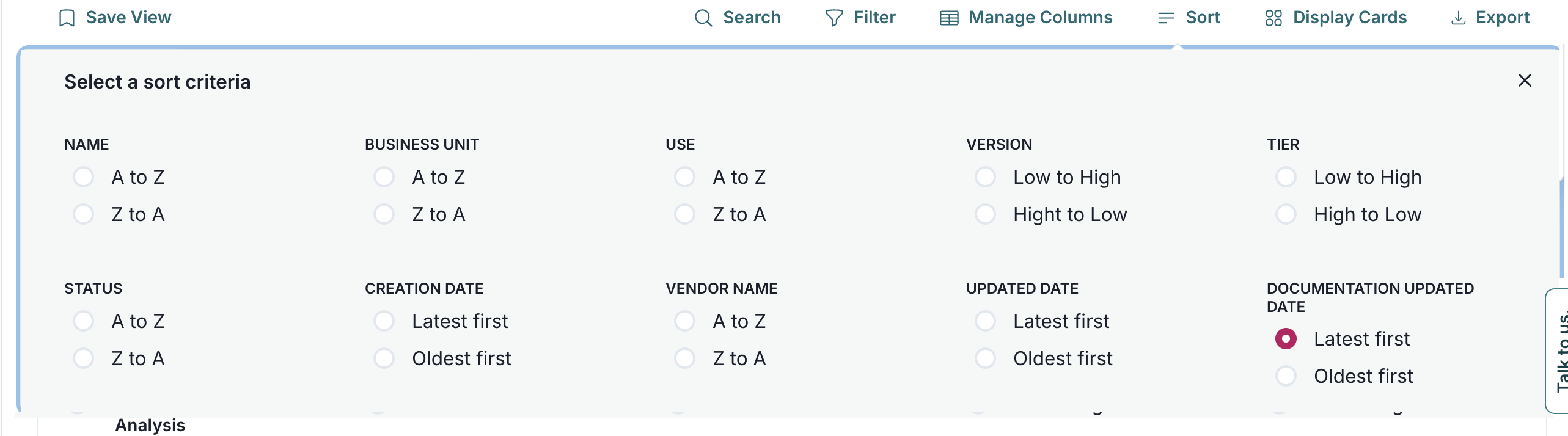 A sorting criteria selection interface is displayed with a white background and a grid layout. The interface is titled Select a sort criteria and contains multiple sections, each with radio button options. Sections include Name, Business Unit, Use, Version, Tier, Status, Creation Date, Vendor Name, Updated Date, and Documentation Updated Date. Each section provides two sorting options such as A to Z and Z to A for Name, and Latest first and Oldest first for dates. The Documentation Updated Date section has the Latest first option selected, indicated by a filled pink radio button.